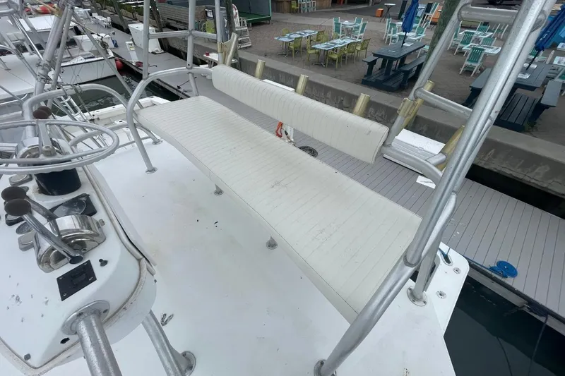 Slide: The Image of 1997 Luhrs 36 SX boat helm with white seating and fishing rod holders. - 44