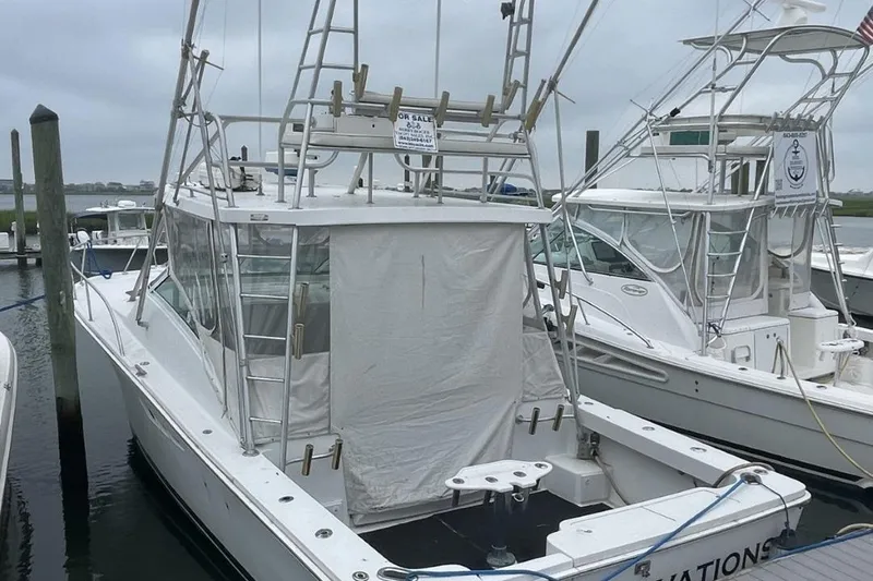 Slide: The Image of 1997 Luhrs 36 SX boat docked at marina, featuring fishing tower and covered cockpit. - 8