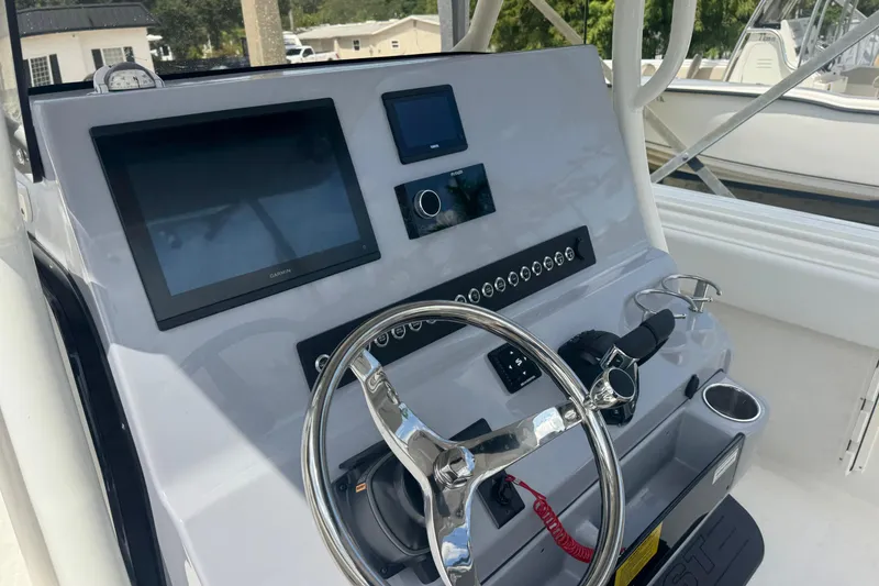 Slide: The Image of 2025 Key West 263 FS boat dashboard with steering wheel and electronic displays. - 11