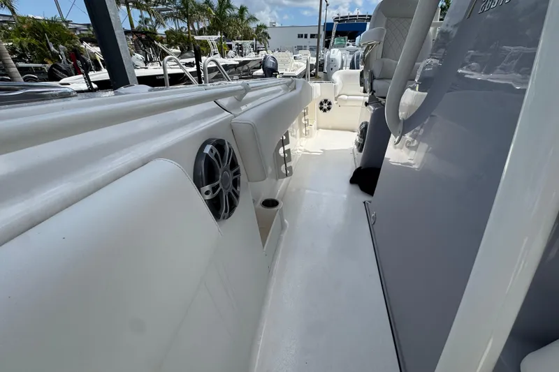 Slide: The Image of 2025 Key West 263 FS boat interior with seating and speakers, docked under clear skies. - 17