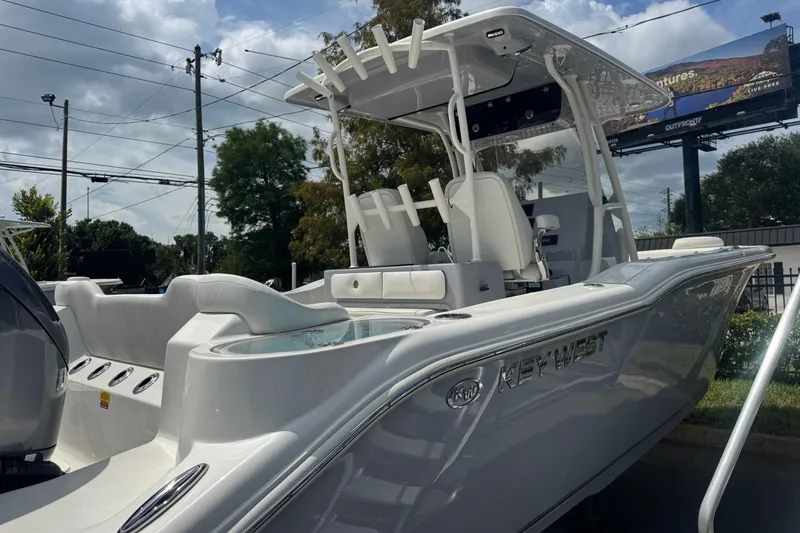Slide: The Image of 2025 Key West 263 FS boat with sleek design, parked outdoors under cloudy sky. - 5