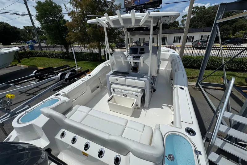 Slide: The Image of 2025 Key West 263 FS boat with spacious seating and modern console, parked outdoors. - 7