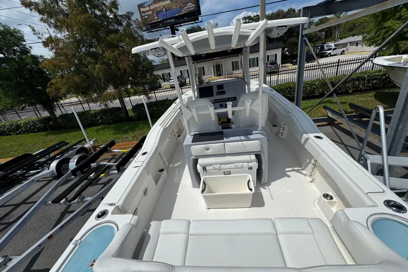 Slide: The Image of 2025 Key West 263 FS boat interior with seating and console, parked outdoors. - 8