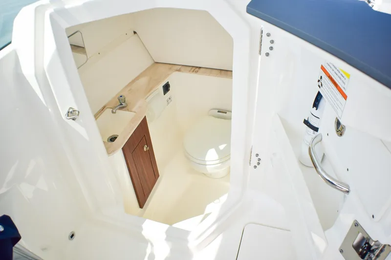 Slide: The Image of 2023 Pursuit DC 266 Dual Console boat interior with compact bathroom amenities. - 14