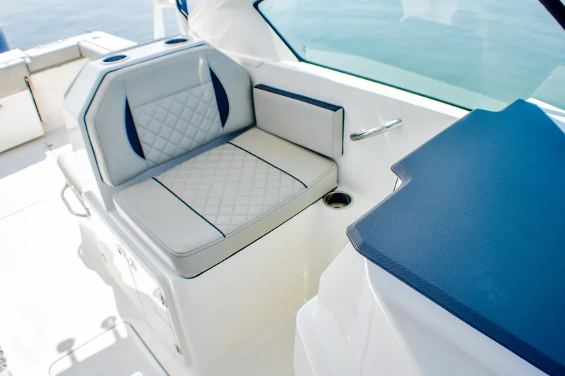 Slide: The Image of 2023 Pursuit DC 266 Dual Console boat interior with cushioned seating and cup holders. - 18