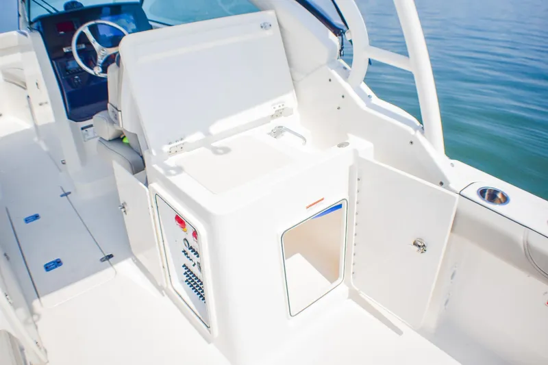 Slide: The Image of 2023 Pursuit DC 266 Dual Console boat interior with helm and storage compartments. - 20