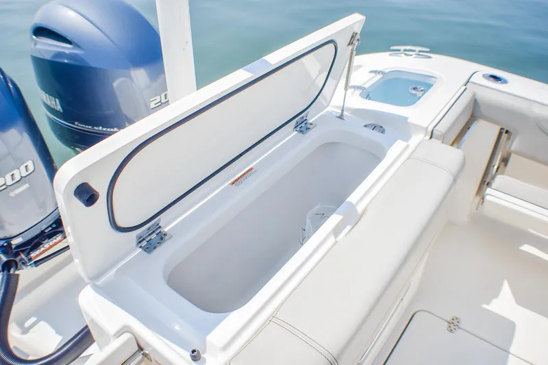 Slide: The Image of 2023 Pursuit DC 266 Dual Console boat with open storage compartment and twin Yamaha engines. - 23