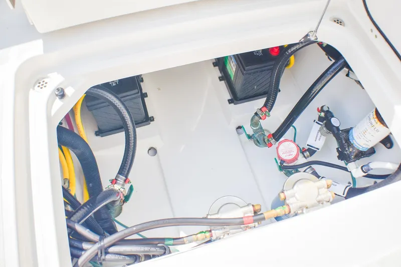 Slide: The Image of 2023 Pursuit DC 266 Dual Console boat engine compartment with batteries and wiring. - 24