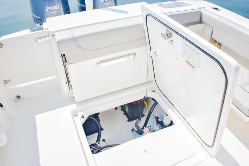 Slide: The Image of 2023 Pursuit DC 266 Dual Console boat storage compartment open, revealing interior components. - 25