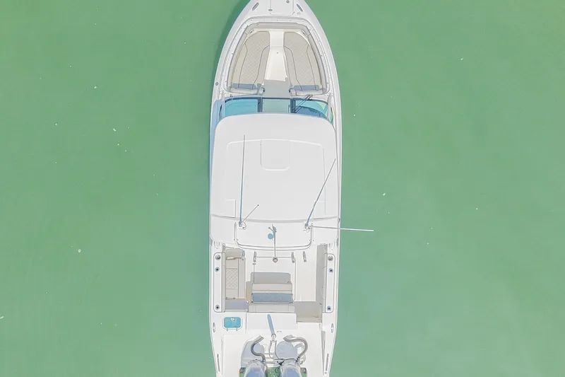 Slide: The Image of Aerial view of 2023 Pursuit DC 266 Dual Console boat on calm green water. - 4