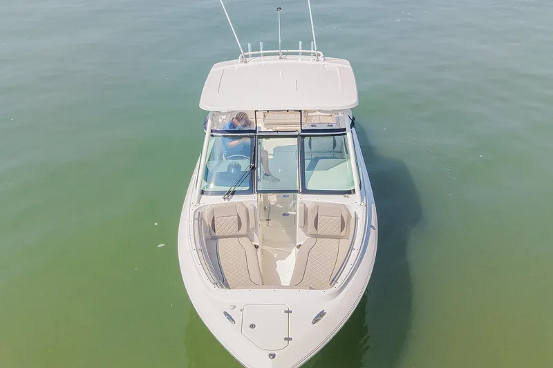 Slide: The Image of 2023 Pursuit DC 266 Dual Console boat on calm water, aerial view. - 5