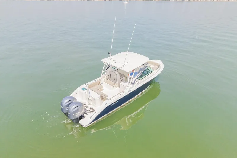 Slide: The Image of 2023 Pursuit DC 266 Dual Console boat on calm water, aerial view. - 6