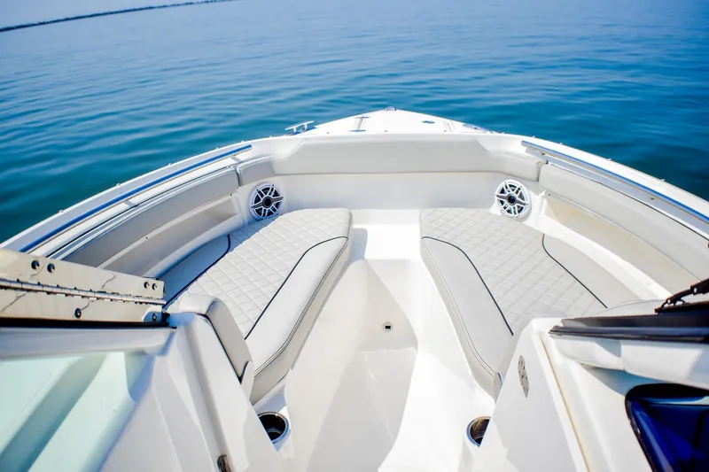 Slide: The Image of 2023 Pursuit DC 266 Dual Console boat interior with cushioned seating on calm water. - 8