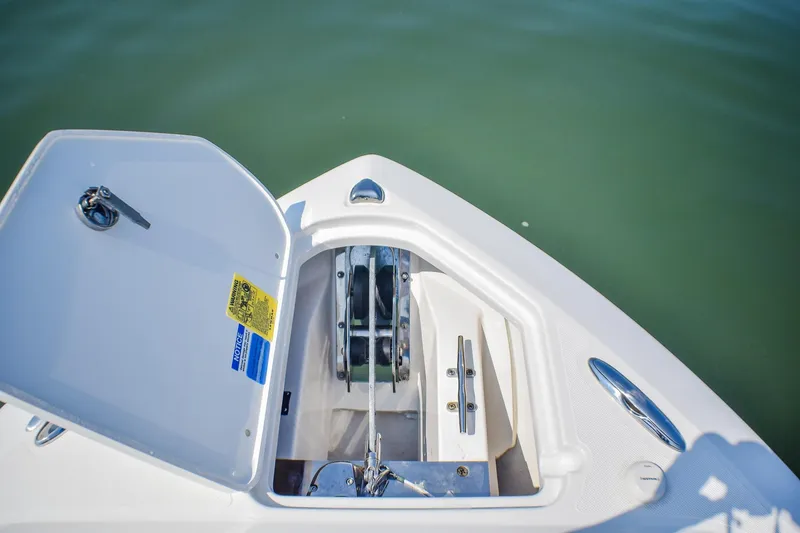 Slide: The Image of 2023 Pursuit DC 266 Dual Console anchor compartment, open on calm water. - 9