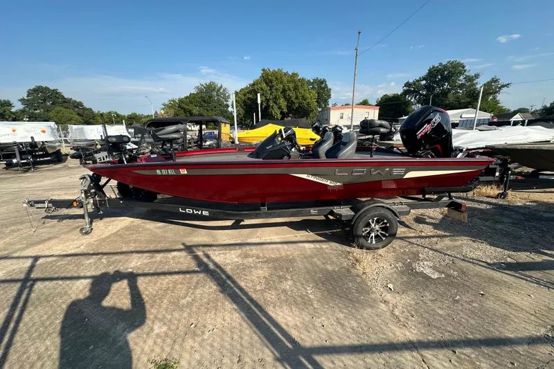 Slide: The Image of 2022 Lowe Stinger 188 boat on trailer, red exterior, parked outdoors. - 13