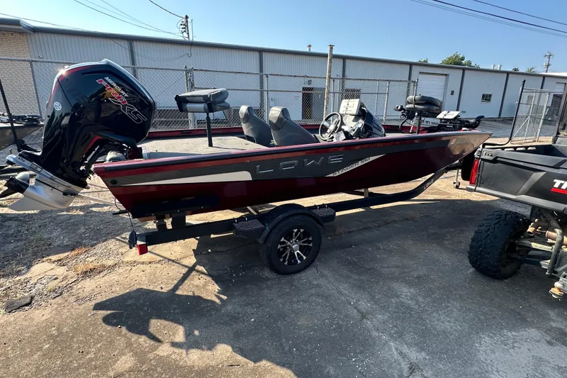 Slide: The Image of 2022 Lowe Stinger 188 boat with Mercury engine on trailer, parked outdoors. - 16