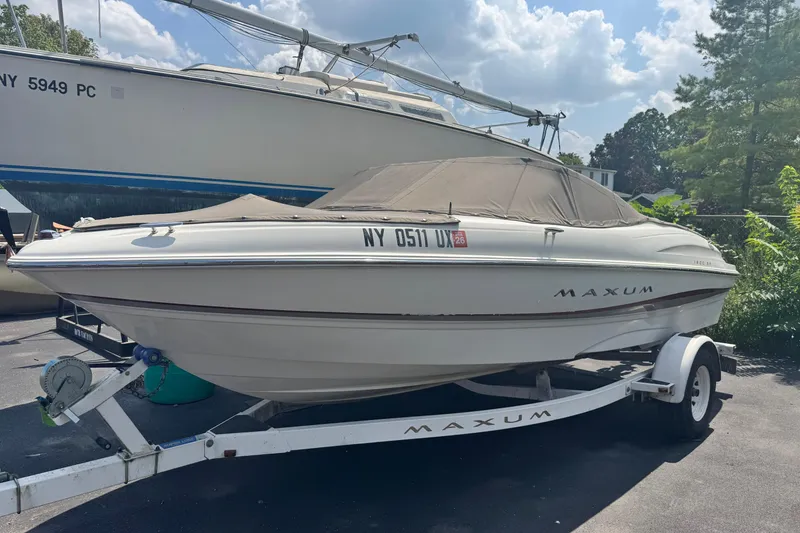 The Image of 2002 Maxum 1800 SR boat on trailer, parked outdoors under a cloudy sky. - 1