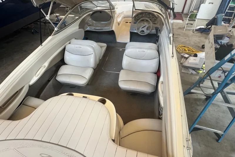 Slide: The Image of 2002 Maxum 1800 SR boat interior with white seating and steering wheel in a garage. - 25