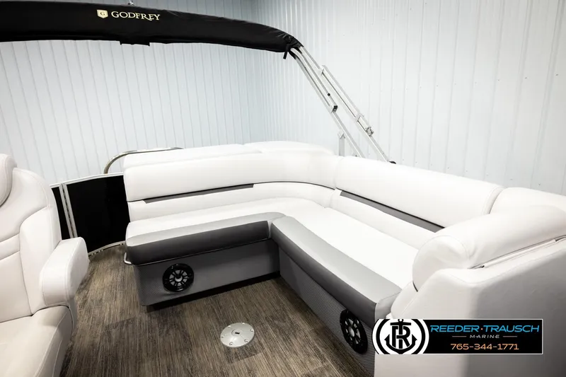Slide: The Image of 2023 Godfrey SW2286C pontoon boat interior with white seating and wood flooring. - 21