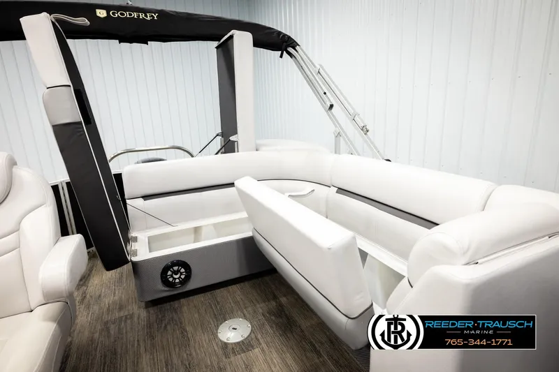 Slide: The Image of 2023 Godfrey SW2286C pontoon boat interior with white seating and storage compartment. - 23