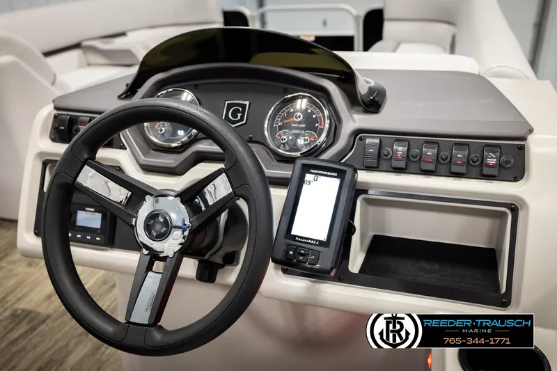 Slide: The Image of 2023 Godfrey SW2286C boat dashboard with steering wheel, gauges, and control panel. - 26