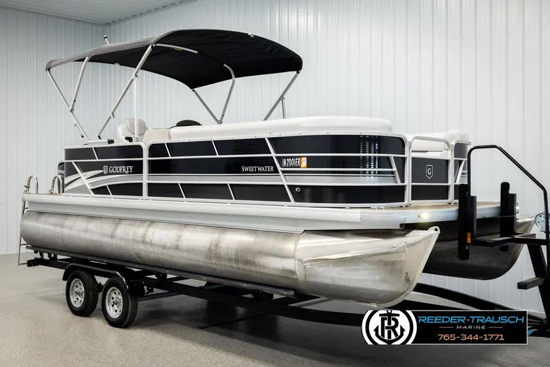Slide: The Image of 2023 Godfrey SW2286C pontoon boat with canopy on trailer in showroom. - 3