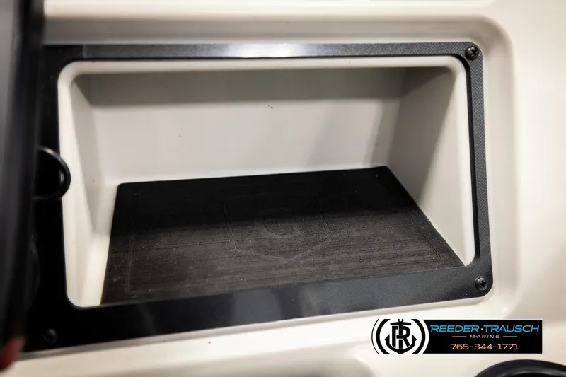 Slide: The Image of Open storage compartment in 2023 Godfrey SW2286C boat, featuring black trim and Reeder-Trausch Marine logo. - 36
