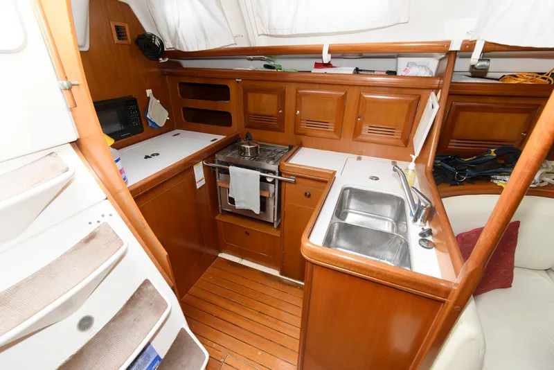 Slide: The Image of Interior of 2002 Beneteau 393 yacht kitchen with wood finish and modern amenities. - 11
