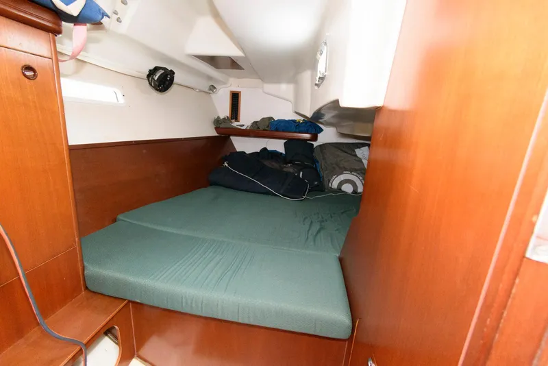 Slide: The Image of Cozy cabin interior of 2002 Beneteau 393 sailboat with green bedding. - 13