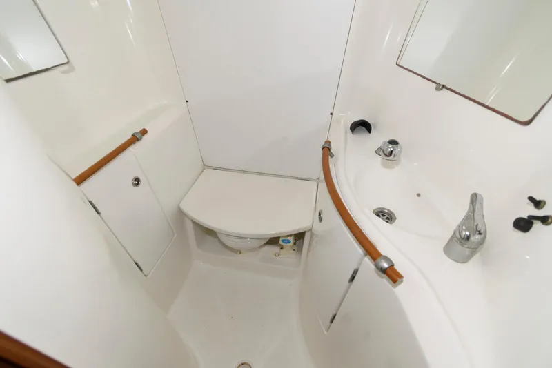Slide: The Image of Compact bathroom in a 2002 Beneteau 393 yacht, featuring a sink and toilet. - 16