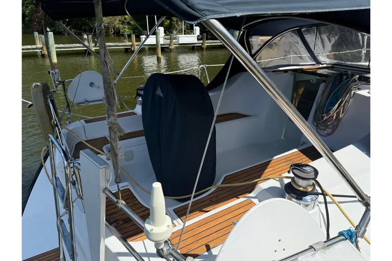 Slide: The Image of 2002 Beneteau 393 sailboat cockpit with wooden deck and covered steering wheel. - 7