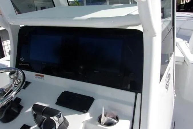Slide: The Image of 2025 Sportsman Heritage 261 boat dashboard with dual screens and steering wheel. - 10