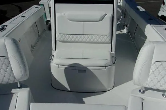 Slide: The Image of 2025 Sportsman Heritage 261 boat interior with white cushioned seating and diamond stitching. - 11