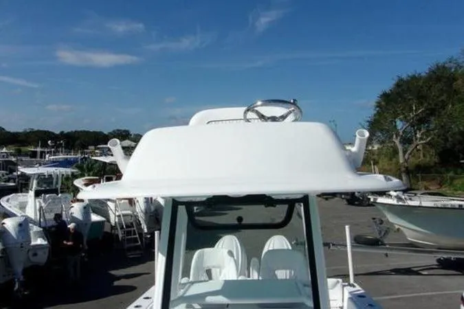 Slide: The Image of 2025 Sportsman Heritage 261 boat, white exterior, parked outdoors under clear blue sky. - 12