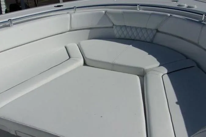 Slide: The Image of 2025 Sportsman Heritage 261 boat with spacious white cushioned seating area. - 15
