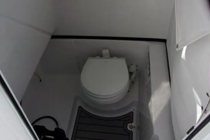 Slide: The Image of 2025 Sportsman Heritage 261 boat interior with compact marine toilet. - 7