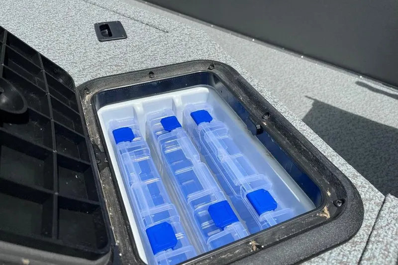 Slide: The Image of Storage compartment with blue-lidded containers in 2026 War Eagle 754VS Stick Steer boat. - 14
