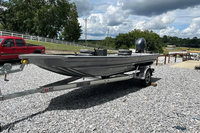 Slide: The Image of 2026 War Eagle 754VS Stick Steer boat on trailer, parked on gravel lot. - 3