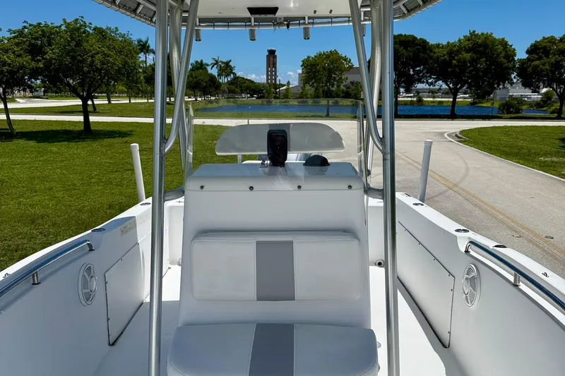 Slide: The Image of 2002 Sea Pro 220 Center Console boat interior with seating, parked near a scenic lake. - 20