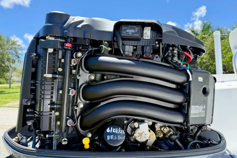 Slide: The Image of Close-up of a 2002 Sea Pro 220 Center Console boat engine under a clear blue sky. - 24