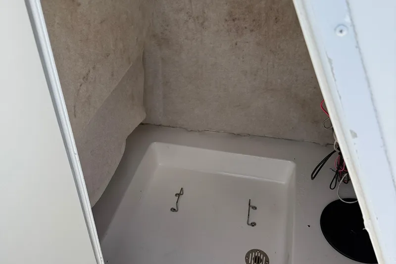 Slide: The Image of 2002 Sea Pro 220 Center Console interior storage compartment with wiring visible. - 27