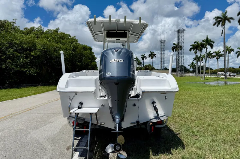 Slide: The Image of 2002 Sea Pro 220 Center Console boat with powerful outboard motor, parked on grassy area. - 6