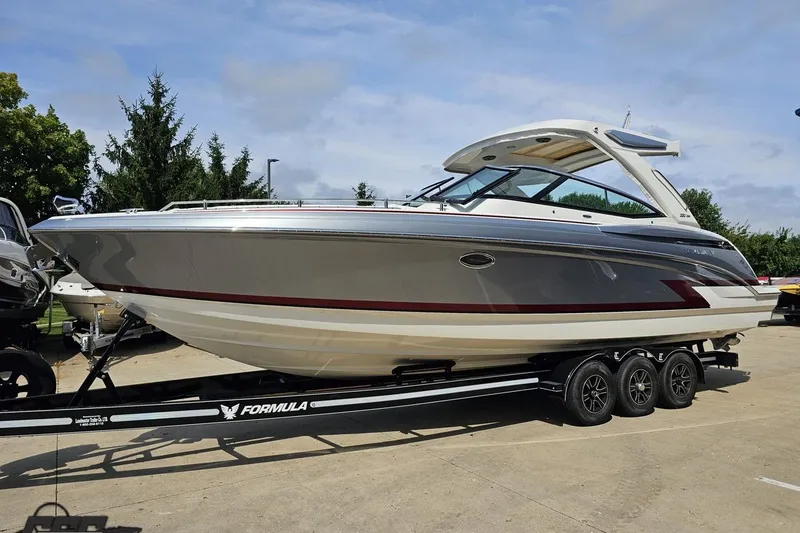 Slide: The Image of 2020 Formula 330 Crossover Bowrider on trailer, sleek design, parked outdoors. - 16