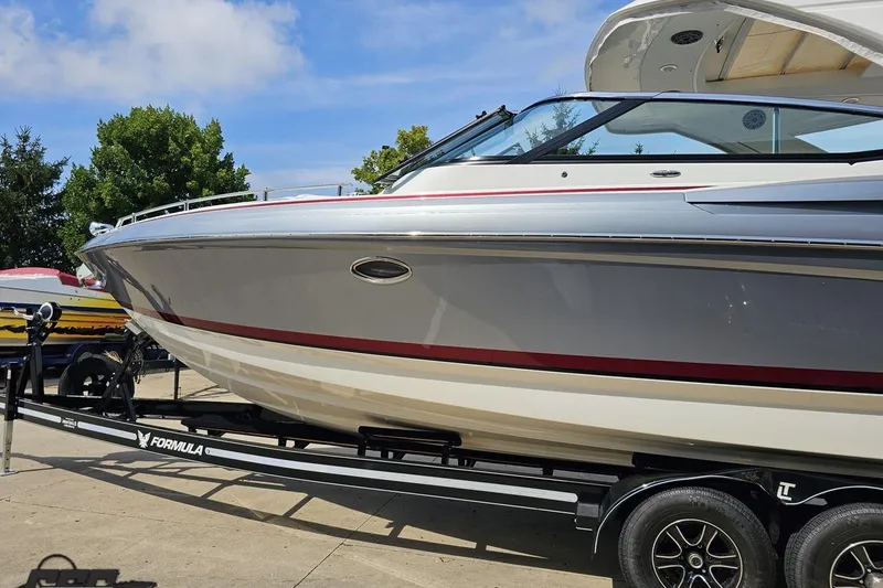 Slide: The Image of 2020 Formula 330 Crossover Bowrider on trailer, sleek design, sunny day. - 19