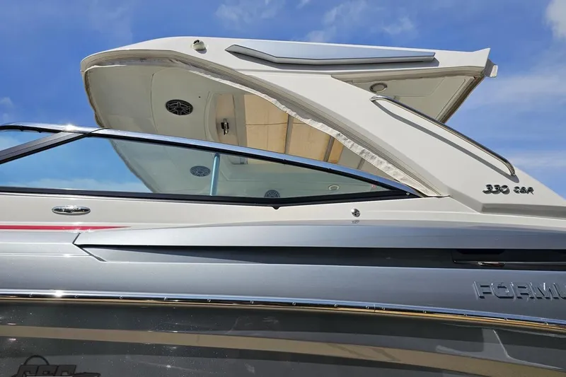 Slide: The Image of 2020 Formula 330 Crossover Bowrider boat, sleek design under blue sky. - 21