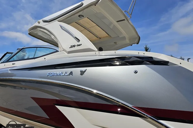 Slide: The Image of 2020 Formula 330 Crossover Bowrider boat with sleek design under blue sky. - 26