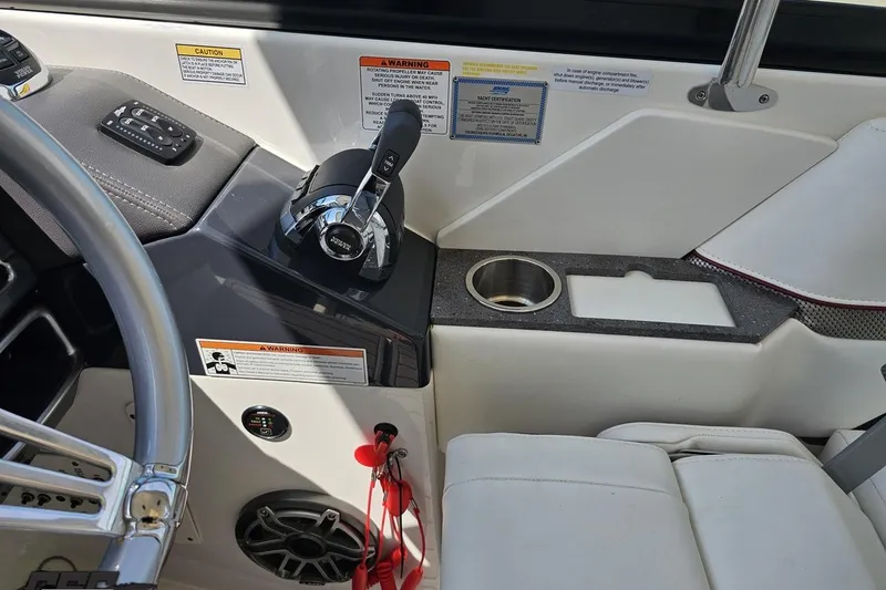 Slide: The Image of 2020 Formula 330 Crossover Bowrider cockpit with throttle controls and cup holder. - 67