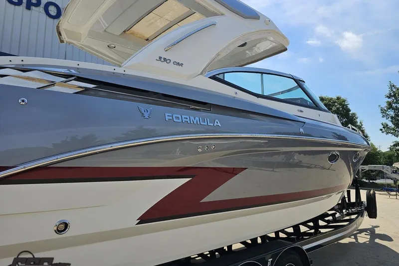 Slide: The Image of 2020 Formula 330 Crossover Bowrider boat on trailer, sleek design, sunny day. - 9
