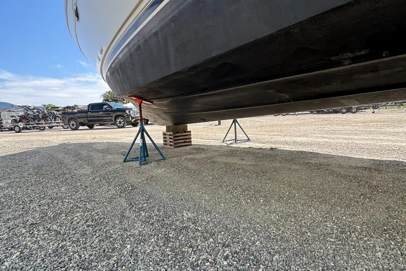 Slide: The Image of 2004 Carver 360 Mariner boat on stands in a gravel lot, with truck in background. - 12