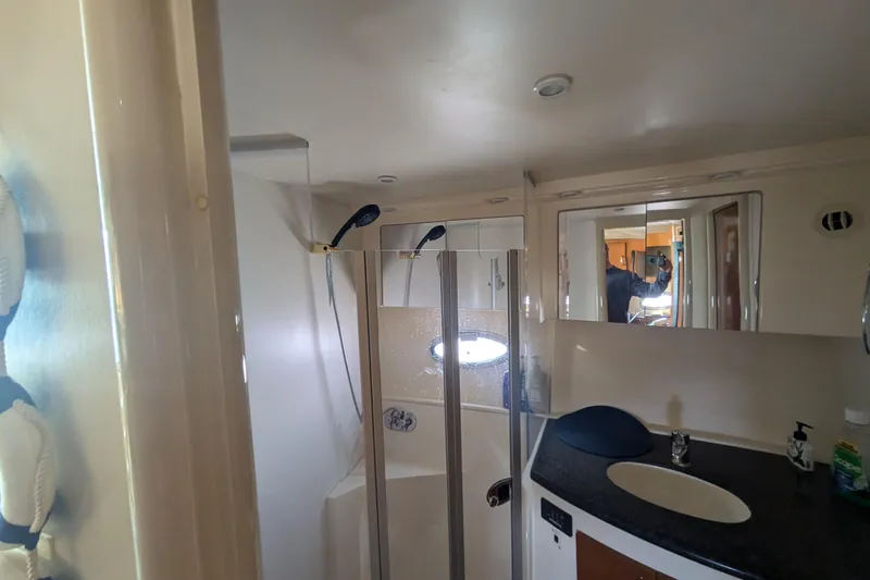 Slide: The Image of 2004 Carver 360 Mariner bathroom with shower, sink, and mirrored cabinet. - 18